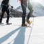 Zwei Personen beim Schneeschuhwandern in den Bergen bei Sonnenschein